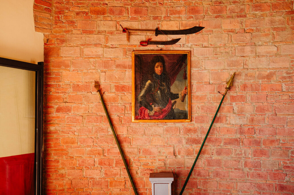 Parete in mattoni con quadro e arredi storici nella location del matrimonio