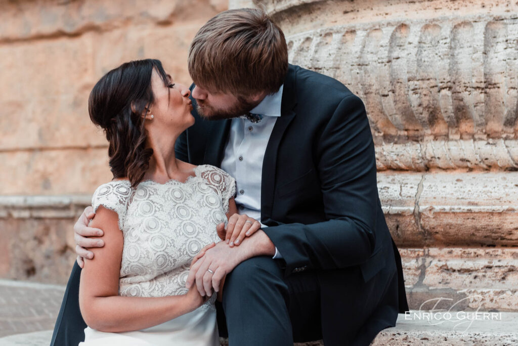 Sposi seduti si scambiano un bacio nel centro storico di Pienza