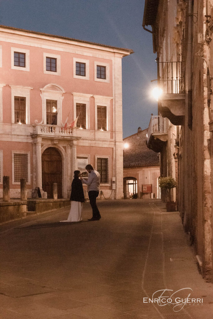 Coppia di sposi in una piazza toscana illuminata di sera