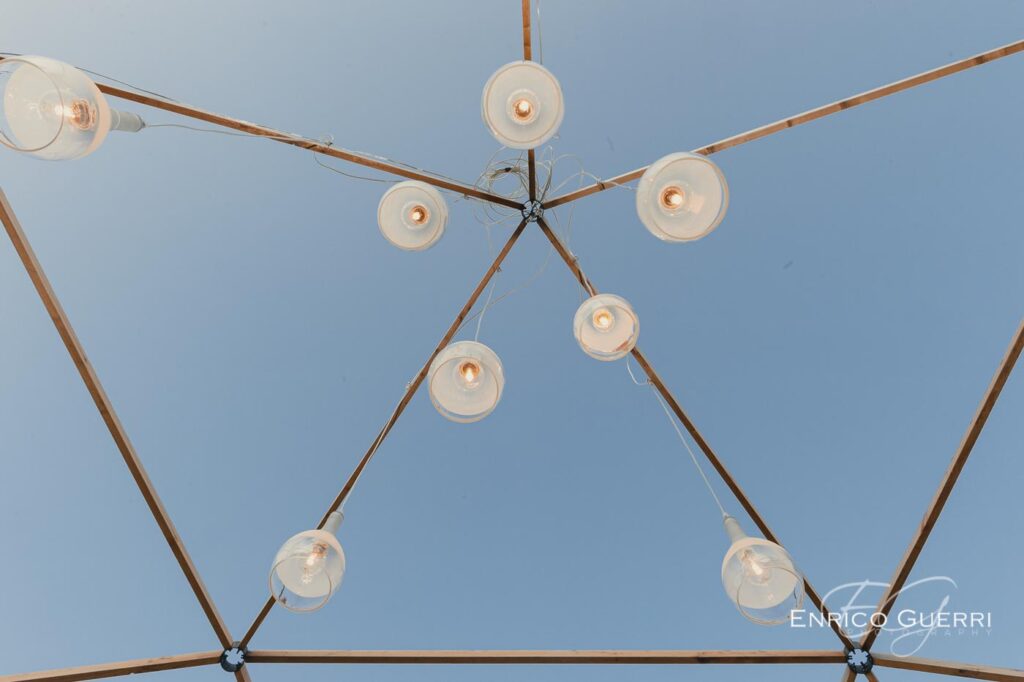 Una creazione di lampade sospese e linee geometriche fotografate contro il cielo